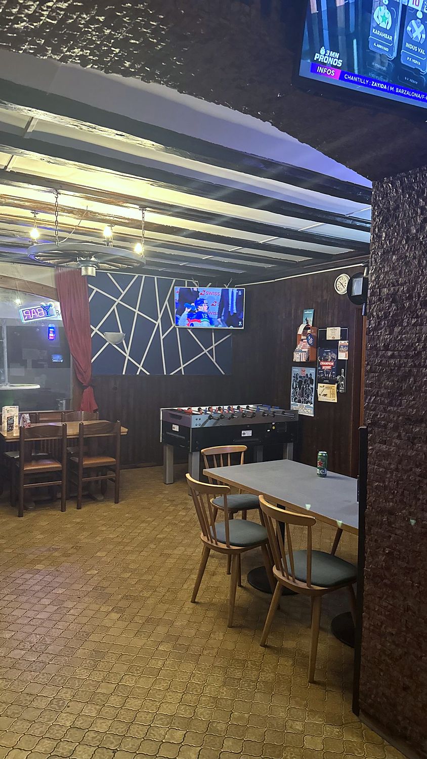 Baby-foot et tables dans la salle arrière du bar